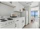 White kitchen with stove, refrigerator, and herringbone backsplash at 2207 S Ocean Blvd. # 1015, Myrtle Beach, SC 29577