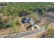 Aerial view showcasing the home's location on a wooded lot with a paved driveway at 6174 Highway 66, Loris, SC 29569