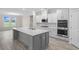 Modern kitchen with gray island, white cabinets, and stainless steel appliances at 1906 Woodrush Loop, Little River, SC 29566