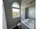 Stylish bathroom with a white vanity and an arched window at 2401 Duffy St., North Myrtle Beach, SC 29582