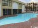 Outdoor kidney-shaped swimming pool with brick decking and lounge chairs at 1207 S Ocean Blvd. # 20203, Myrtle Beach, SC 29577