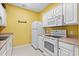 Small kitchen with white appliances and yellow walls at 2050 Cross Gate Blvd. # 303, Myrtle Beach, SC 29575