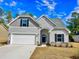 Two-story home with gray siding, white garage door, and stone accents at 370 Long Meadow Dr., Loris, SC 29569