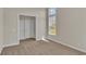 Spacious bedroom with carpet flooring, large window, and access to hallway at 1224 Colusa Ct., Little River, SC 29566