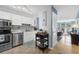 Bright kitchen with white cabinets, stainless steel appliances and a view into living room at 7700 Porcher Dr. # 3207, Myrtle Beach, SC 29572