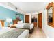 Bedroom with two beds, wooden furniture, a TV, and teal walls at 4800 S Ocean Blvd. # 615, North Myrtle Beach, SC 29582