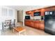 Compact kitchen with wood cabinetry, black appliances, and dining table at 4800 S Ocean Blvd. # 615, North Myrtle Beach, SC 29582