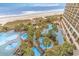Elevated view of resort pool with palm trees and lounge chairs at 4800 S Ocean Blvd. # 615, North Myrtle Beach, SC 29582