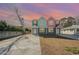 Two-story duplex with gray, teal, and pink exterior, evening view at 503 30Th Ave. N, Myrtle Beach, SC 29577
