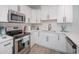Modern white kitchen with stainless steel appliances and quartz countertops at 503 30Th Ave. N, Myrtle Beach, SC 29577