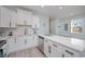 Open concept kitchen boasts white cabinets, stainless steel appliances, and a breakfast bar at 503 30Th Ave. N, Myrtle Beach, SC 29577