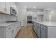 Modern kitchen with gray island, white cabinets, and stainless steel appliances at 3001 Deerberry Place, Longs, SC 29568