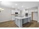 Modern kitchen with gray island, white cabinets, and stainless steel appliances at 3001 Deerberry Place, Longs, SC 29568