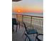Balcony with ocean view and sunset, featuring teal chairs at 2711 S Ocean Blvd. S # 1421, North Myrtle Beach, SC 29582
