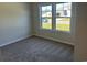 Bright bedroom with gray carpet and large windows at 557 Honeyhill Loop, Conway, SC 29526