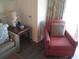 Living room with red armchair and side table at 14290 Ocean Hwy. # 103, Pawleys Island, SC 29585