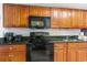 Kitchen with wood cabinets, granite countertops, and black appliances at 1501 S Ocean Blvd. # 936, Myrtle Beach, SC 29577