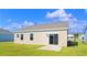 Tan house exterior with sliding glass door to patio and small yard at 3047 Deerberry Place, Longs, SC 29568