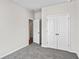 Spacious bedroom with grey carpet, double doors to closet, and access to another room at 3047 Deerberry Place, Longs, SC 29568