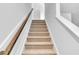 Carpeted staircase with a wooden handrail leading to the upper level at 301 Sandridgebury Dr. # 68, Little River, SC 29566