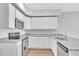 L-shaped kitchen with white cabinets and granite countertops at 301 Sandridgebury Dr. # 68, Little River, SC 29566