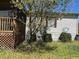 White mobile home with a porch, satellite dish, and landscaping at 12727 Ocean Highway, Pawleys Island, SC 29585