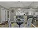 Dining area with glass-top table and chairs, reflecting light from mirror and chandelier at 4601 Greenbriar Dr. # 206A, Little River, SC 29566