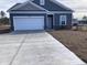 Newly constructed home with gray siding, white garage door, and a large driveway at 1599 Highway 701 South, Loris, SC 29569