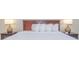 King bed with a wooden headboard and multiple pillows at 2207 S Ocean Blvd. # 915, Myrtle Beach, SC 29577
