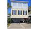Two-story beach house with a yellow exterior, white trim, and black shutters at 5226 Highway 17 Business, Murrells Inlet, SC 29576