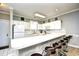 White kitchen cabinets, breakfast bar, and view into living room at 4789 Wild Iris Dr. # 203, Myrtle Beach, SC 29577
