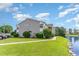 Gray building with landscaping, parking, and a pond view at 8725 Chandler Dr. # F, Surfside Beach, SC 29575