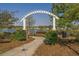 White archway entrance to a community with a pond and homes in the background at 1433 Beaumont Way, Myrtle Beach, SC 29577
