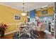 Charming dining area with white table and chairs, yellow walls at 4396 Baldwin Ave. # 109, Little River, SC 29566