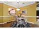 Bright dining area with white table and yellow walls at 4396 Baldwin Ave. # 109, Little River, SC 29566