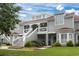 Gray two-story townhome with a red roof, stairs, and landscaping at 4396 Baldwin Ave. # 109, Little River, SC 29566