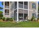 Tan building exterior with screened porch and bicycle, showcasing a welcoming entrance at 242 Sun Colony Blvd. # 101, Longs, SC 29568