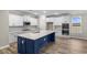Modern kitchen with white cabinets, blue island, and stainless steel appliances at 297 Broughton Dr., Myrtle Beach, SC 29579