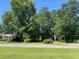 Ranch house with a spacious yard, mature trees, and a tree-lined street at 4155 Pinewood Dr., Mullins, SC 29574