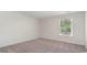 Bright bedroom with neutral walls and carpet, featuring a window with blinds and a view of trees at 507 Harvest Ridge Way, Conway, SC 29527