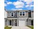 Two story townhome with gray siding, white garage door, and small front yard at 289 Sandridgebury Dr. # 65, Little River, SC 29566