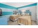 Bedroom with twin beds and a teal accent wall at 4301 S Ocean Blvd. # 1C, North Myrtle Beach, SC 29582