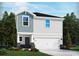 Two-story home with gray siding, a white garage door, and stone accents at 546 Cypress Preserve Circle, Longs, SC 29568