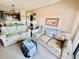 Comfortable living room with floral couches and access to balcony at 207 N Ocean Blvd. # 242, North Myrtle Beach, SC 29582