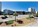 Aerial view of complex with palm trees, road, and buildings at 207 N Ocean Blvd. # 242, North Myrtle Beach, SC 29582
