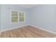 Bright bedroom with light walls, wood-look floors, and a large window at 1616 Sapphire Dr., Longs, SC 29568
