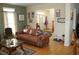 Bright living room with hardwood floors, leather sofa, and view to entryway at 1409 Arbor Rd., Loris, SC 29569
