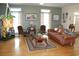 Comfortable living room with hardwood floors, leather sofas, and a large window at 1409 Arbor Rd., Loris, SC 29569
