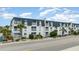 Front view of a two-story building with multiple units, balconies, and palm trees at 5001 N Ocean Blvd. # 2-I, North Myrtle Beach, SC 29582