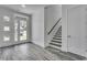 Bright entryway with grey wood-look floors, staircase, and front door at 1817 Woodstork Dr., Conway, SC 29526